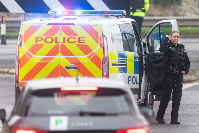 A police officer beside a police van.