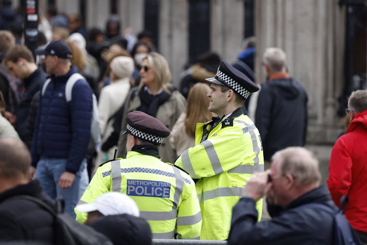 Police officers in hi-vis vests in a street.