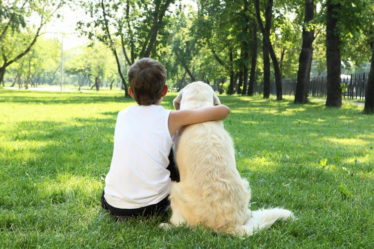 A boy and a dog in a park.