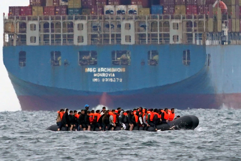 A small boat carrying what is thought to migrants near a tanker in the English Channel.