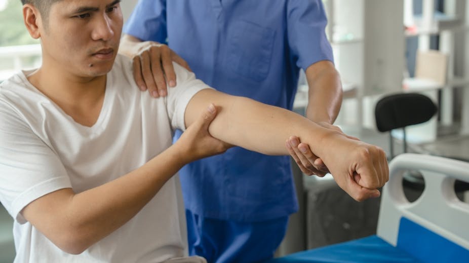 A man's arm being treated by a physiotherapist