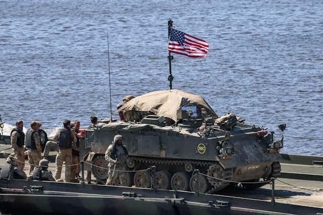 US soldiers with a tank and a US flag.