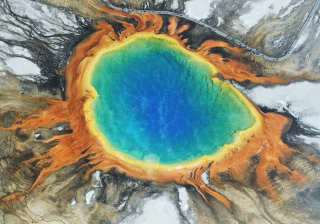 Foto aérea de uma piscina de água multicolorida entre rochas