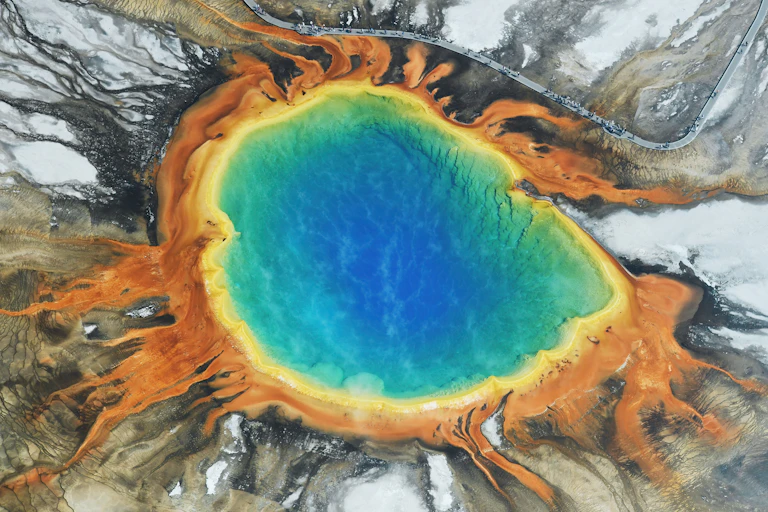 Foto aérea de uma piscina de água multicolorida entre rochas