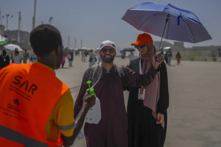 A pilgrim receives cold water spray