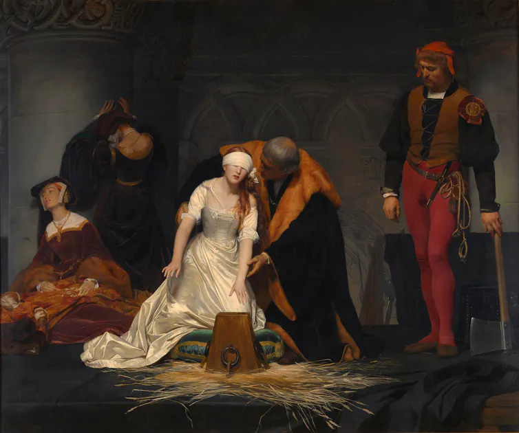 A blindfolded woman being led to the cutting block.