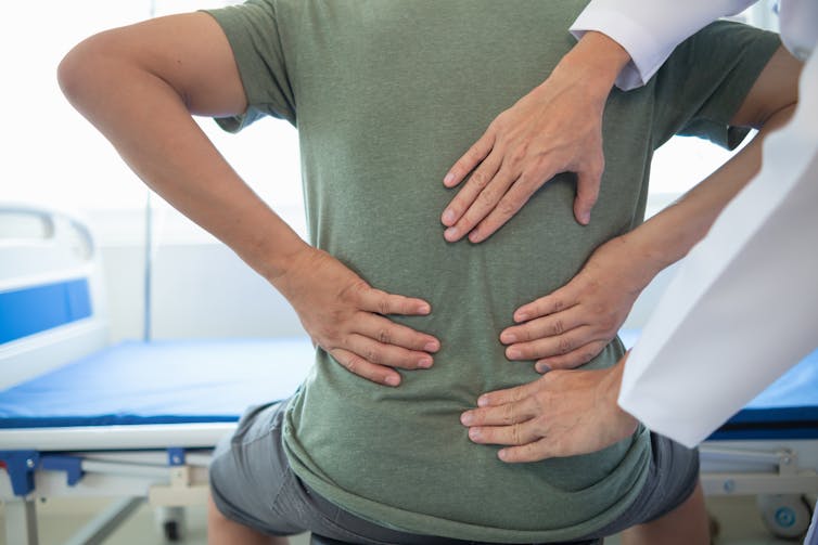 a doctor examines a patient's back