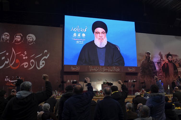Hezbollah supporters listen to a speech by Nasrallah.