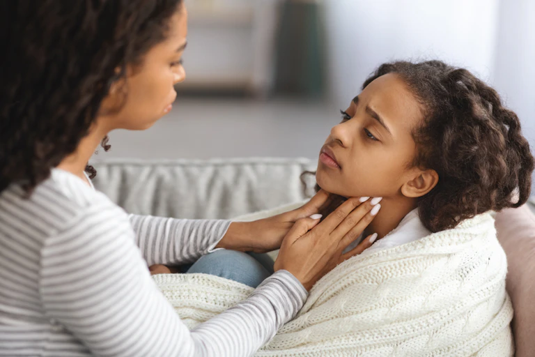Concerned mother feeling sick child's neck