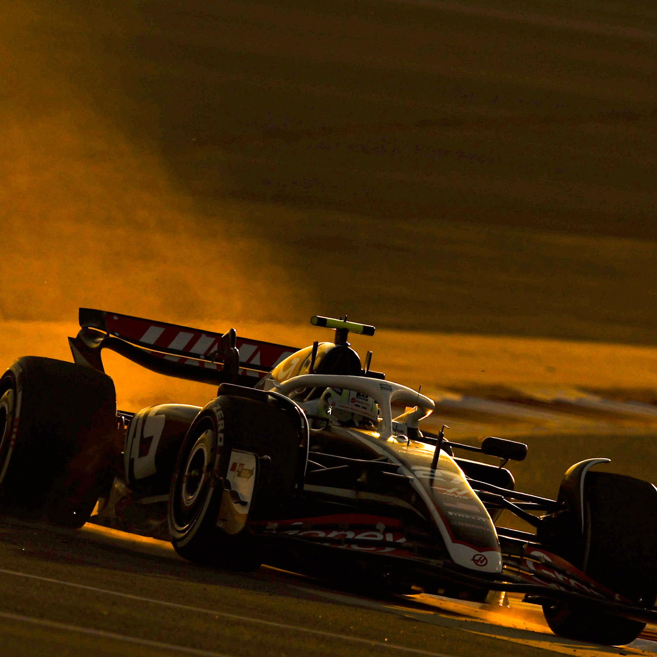 A Formula One car spits out fumes as it turns a corner