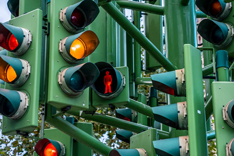 close up of complex system of multiple traffic lights, different coloured lights lit up