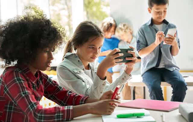 Children using smartphones in a classroom