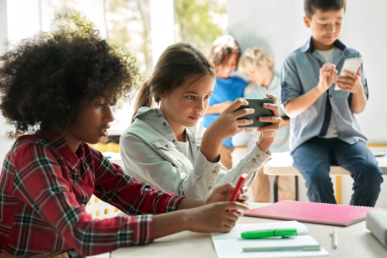 Children using smartphones in a classroom