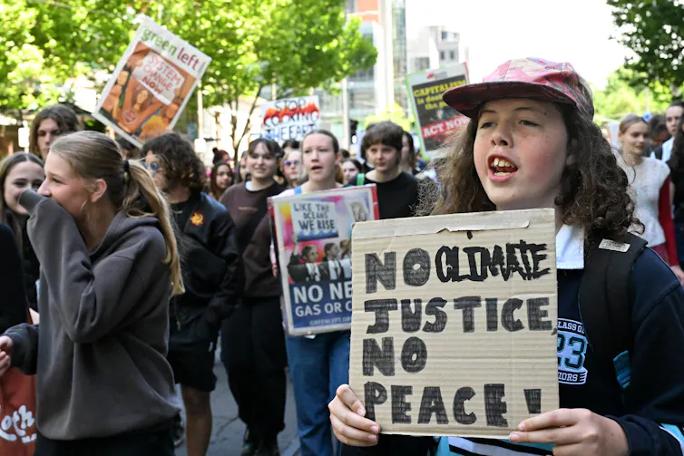A group of school children with placards and posters demanding climate justice.