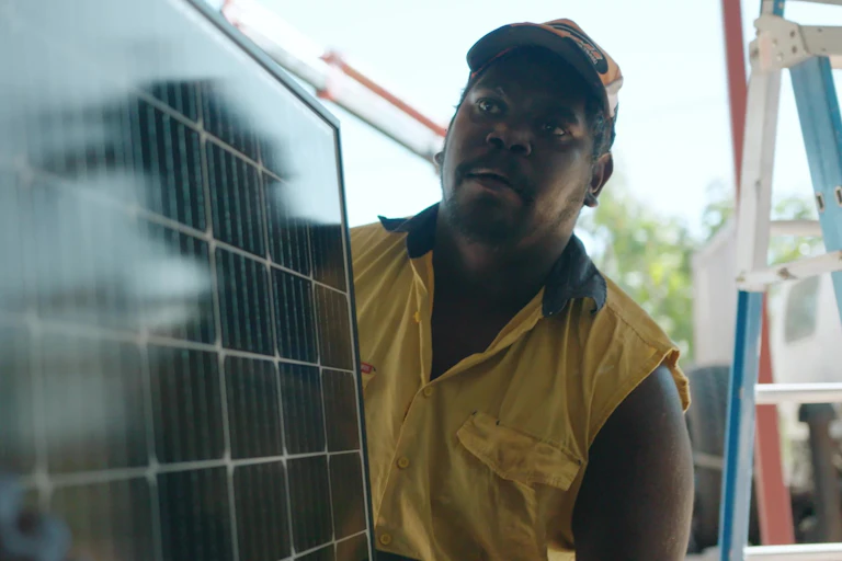Closeup of a worker carrying a solar panel