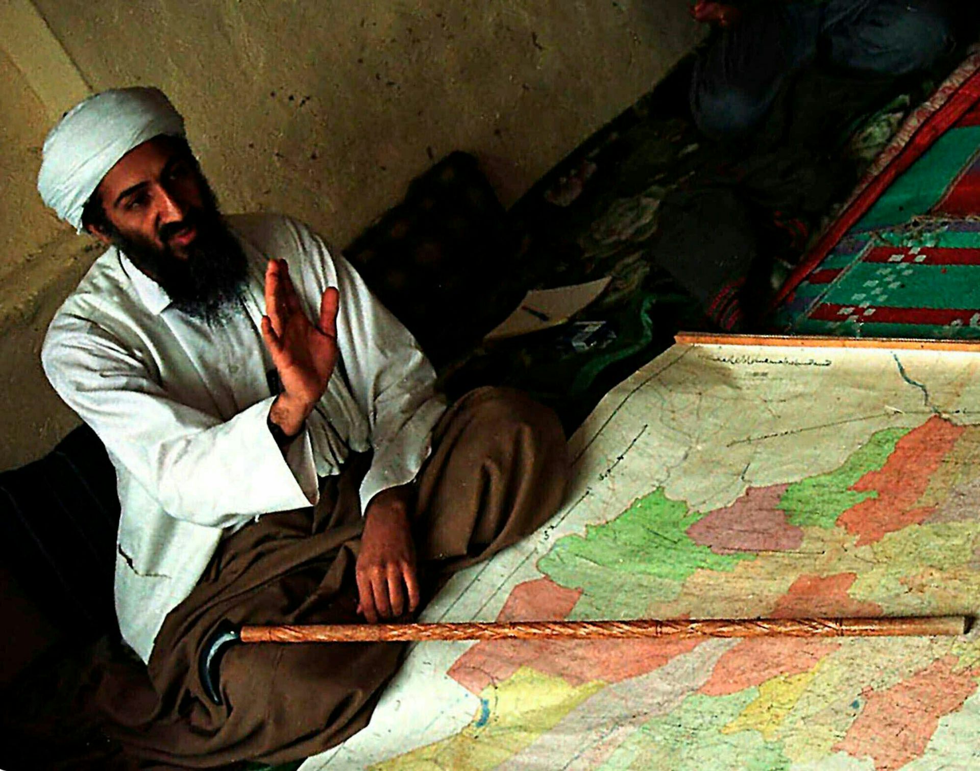 Osama bin Laden sitting in front of a map