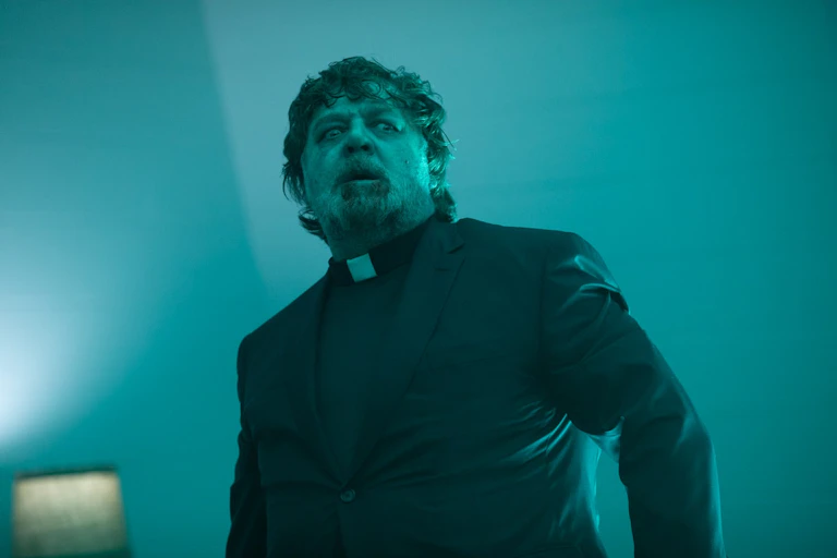 A man dressed as a priest who appears to be possessed