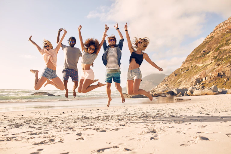 Happy young people jumping on the beach.