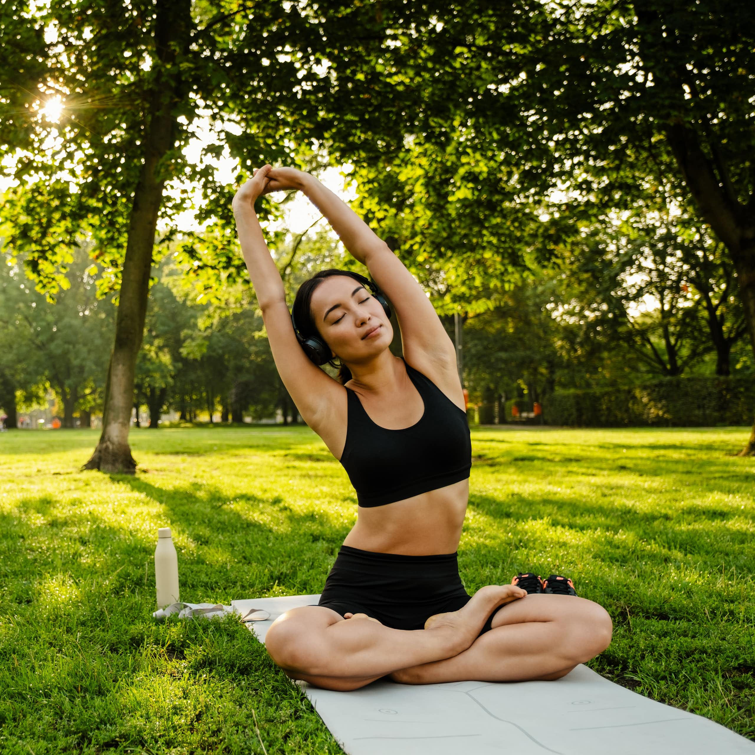 Photo d’une jeune femme pratiquant le yoga dans un parc