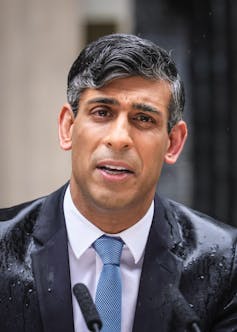 RIshi Sunak molhado da chuva.