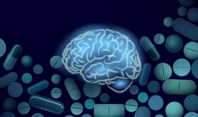 Ilustração azul do cérebro em um fundo de pílulas e cápsulas
