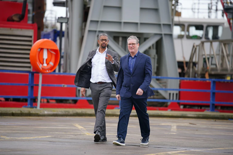 Keir Starmer and Vaughan Gething walking in a port.