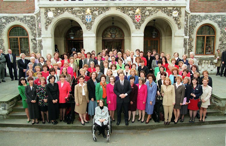 Tony Blair posando para uma foto com mulheres parlamentares.