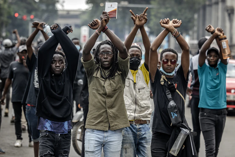 Protesters make signs with their arms