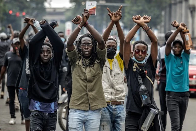 Les manifestants font des signes avec leurs bras.