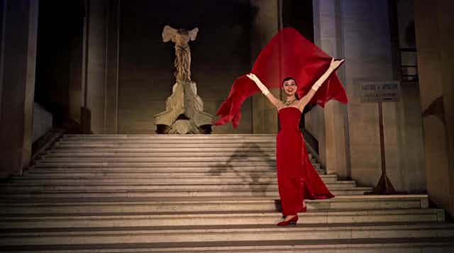 Audrey Hepburn en una escena de 'Una cara con ángel' descendiendo las escaleras del Museo del Louvre ante la Victoria de Samotracia.