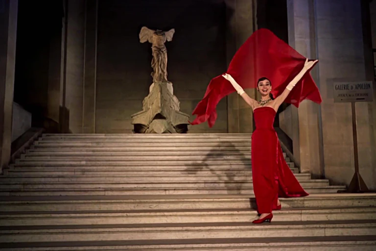 Audrey Hepburn en una escena de 'Una cara con ángel' descendiendo las escaleras del Museo del Louvre ante la Victoria de Samotracia.