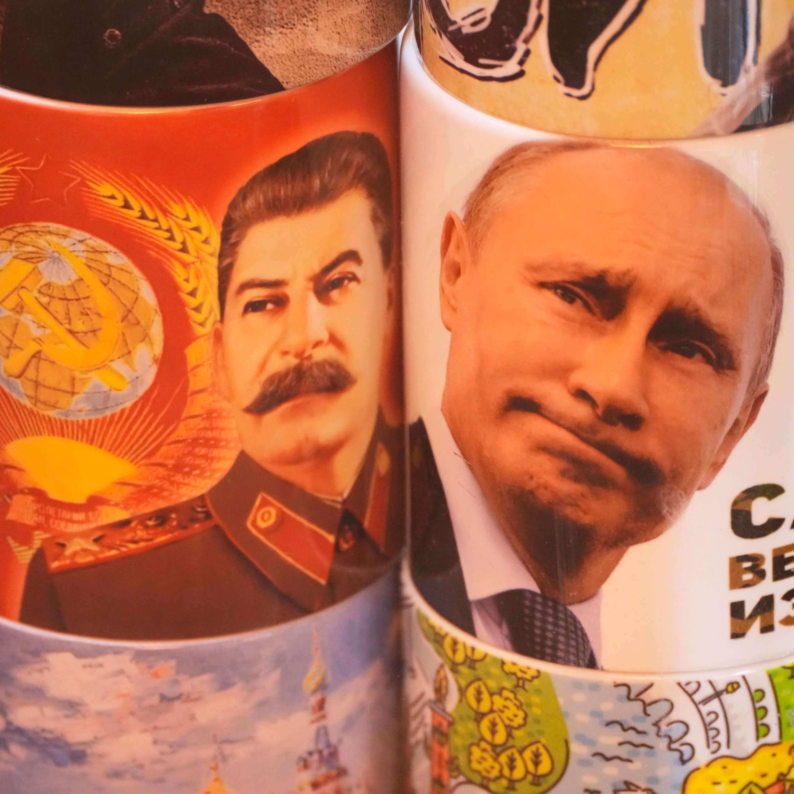 Two cups display the faces of Stalin and Putin.