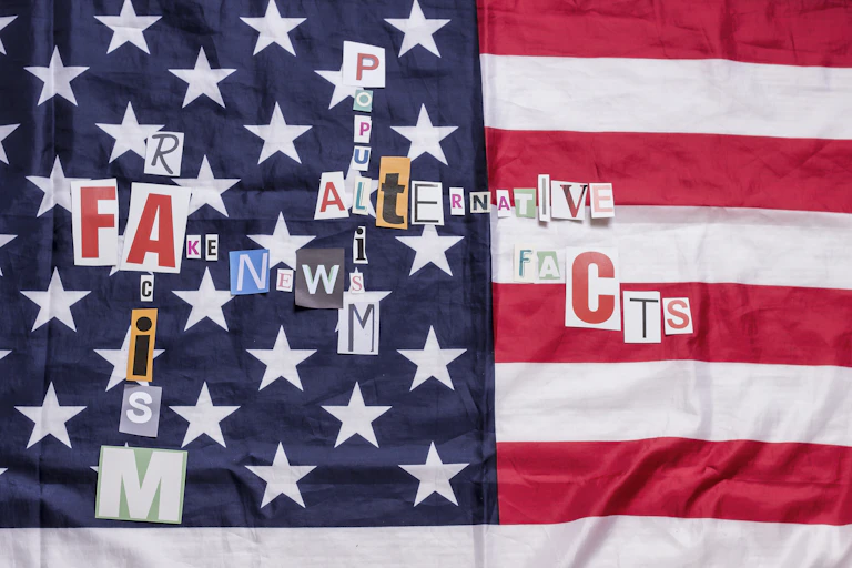 An American flag has cut out letters on it, spelling words like 'Alternative,' 'Facts,' 'Fake,' 'Racism' and 'Populism.'