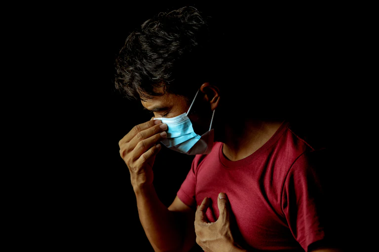 A person wearing a mask, struggling with fatigue