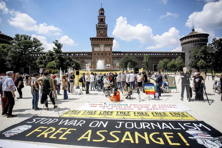 A sign saying stop war on journalism, free Assange is displayed at a protest