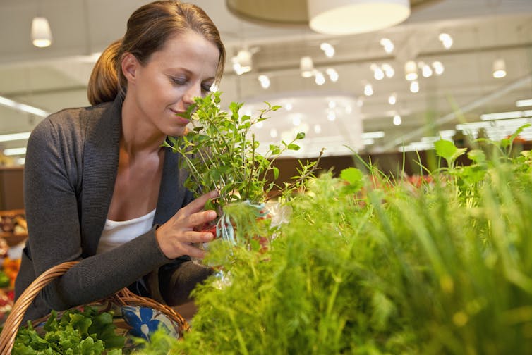 Woman choosing herbs in supermarket