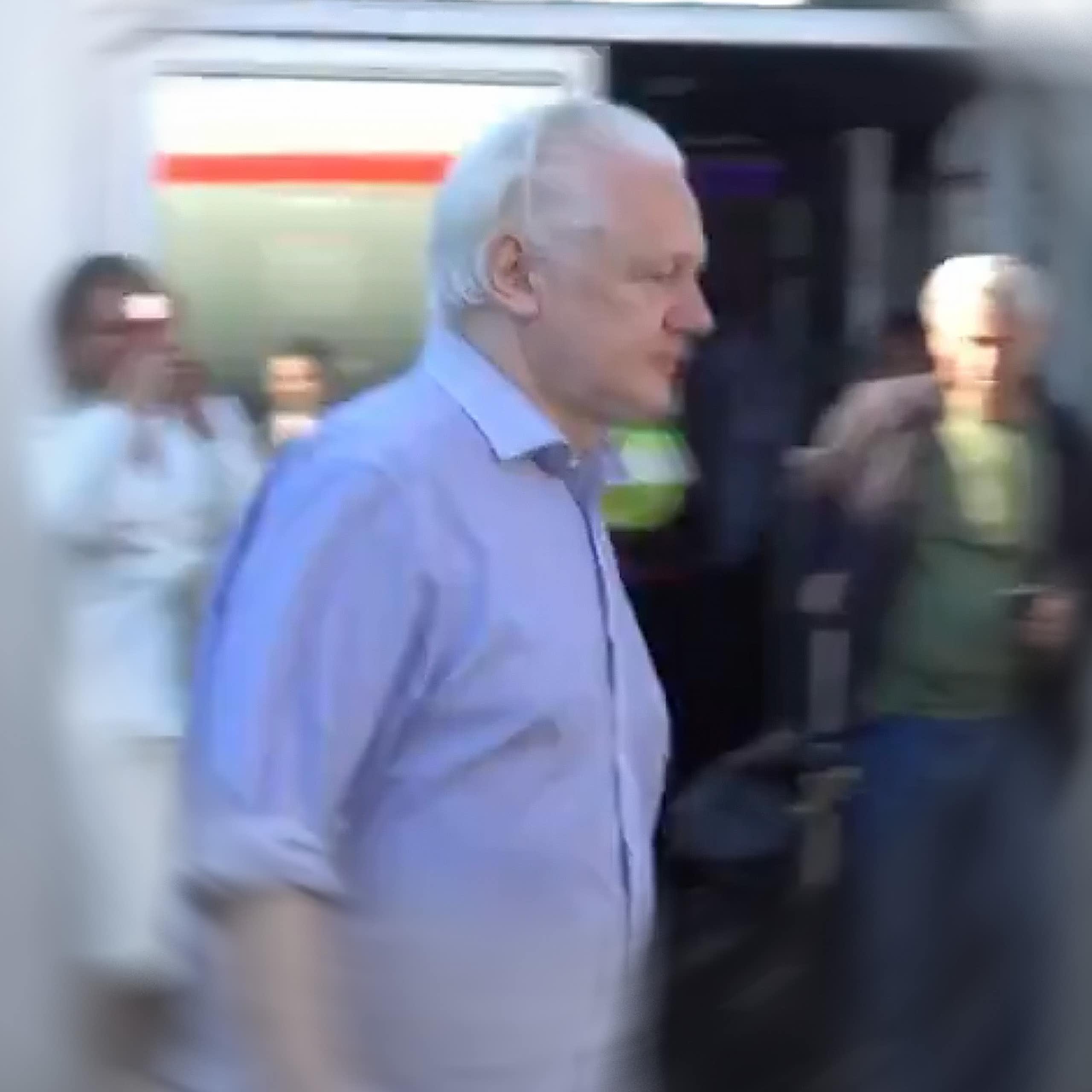 Julian Assange walking to a plane after being released