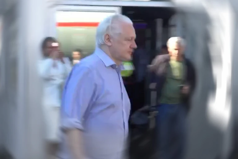 Julian Assange walking to a plane after being released