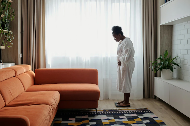 Woman weighs herself in her living room