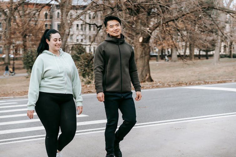 Two people cross the road