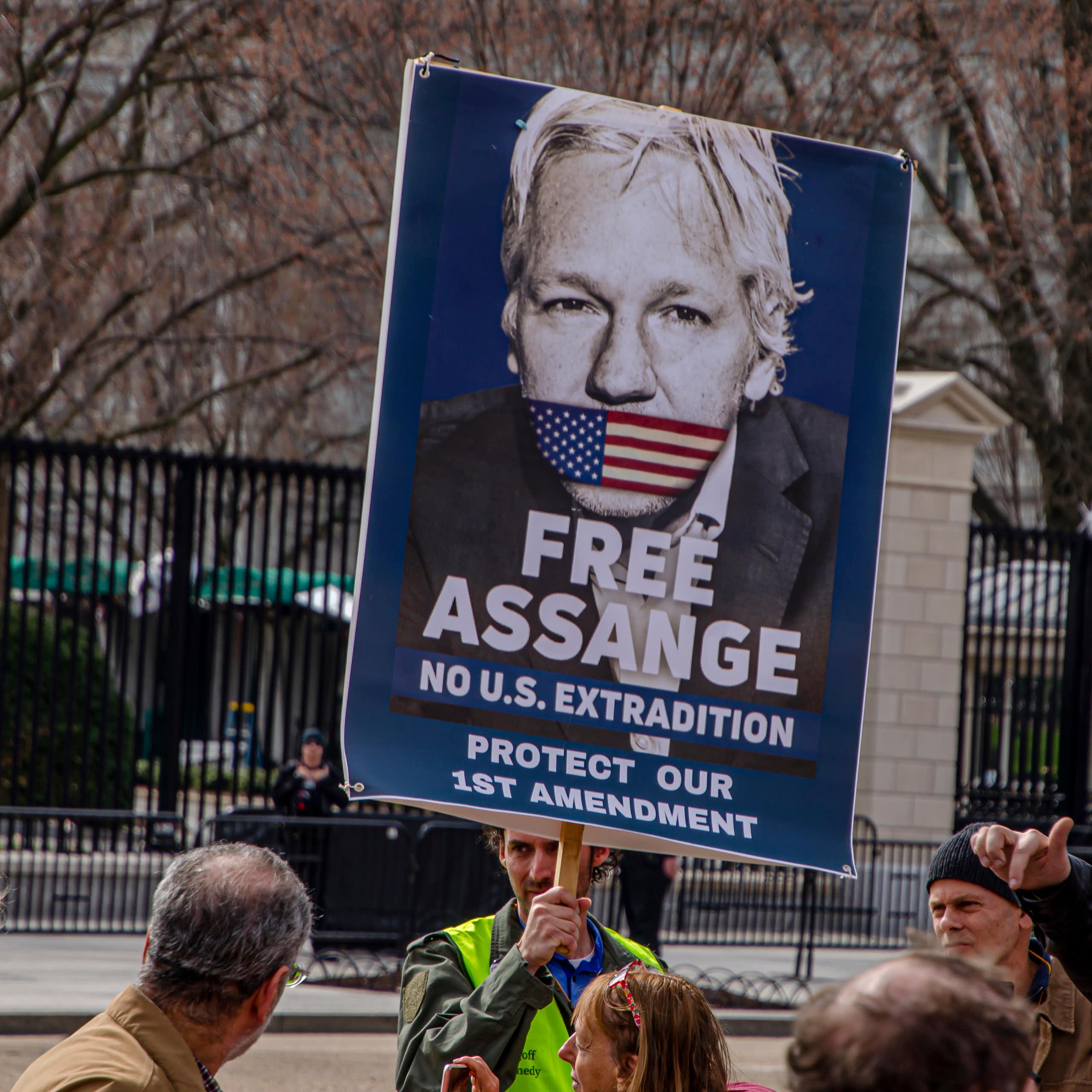 A sign depicts Assange with his mouth taped over