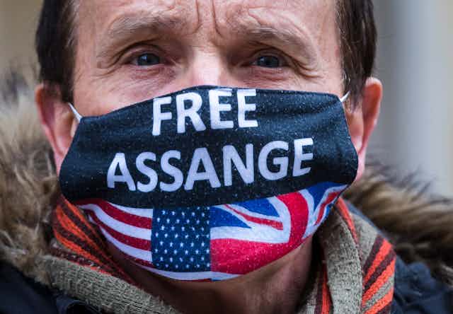 Man wearing face mask with "Free Assange" and US and UK flags printed on it