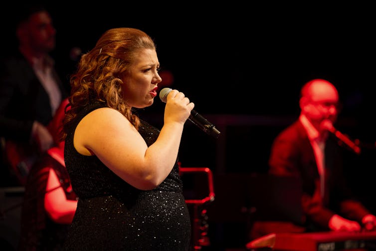 A woman sings.
