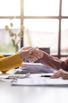 closeup of handshake across a desk