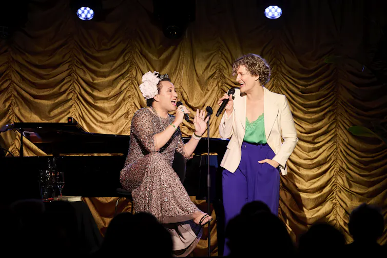 Two women sing.