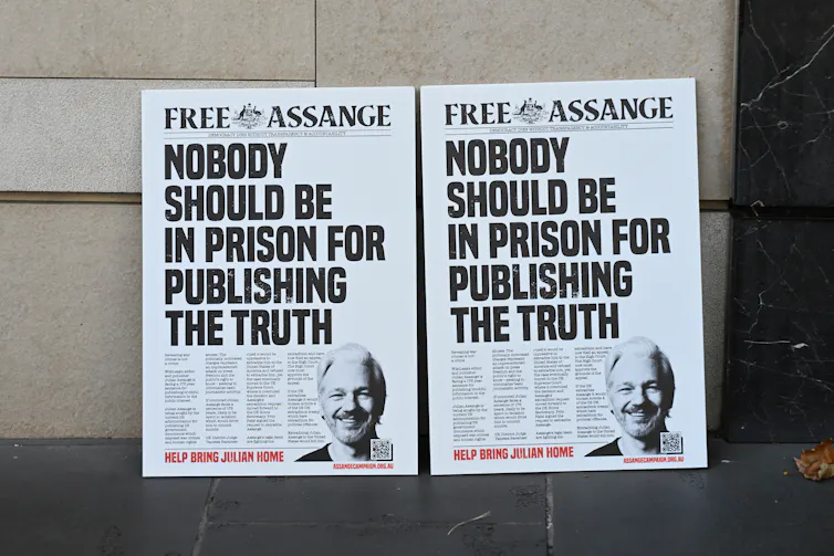 Dos carteles de campaña que dicen LIBEREN A ASSANGE NADIE DEBERÍA ESTAR EN LA PRISIÓN POR PUBLICAR LA VERDAD
