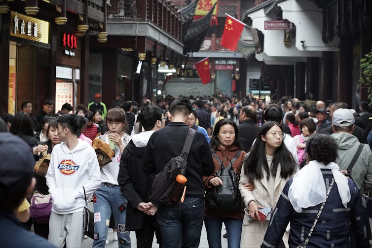 People walking around a busy shopping street in Shanghai.
