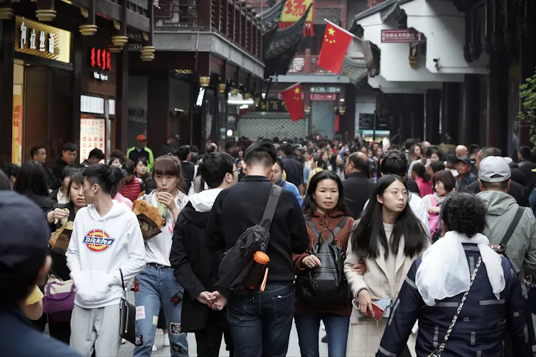 People walking around a busy shopping street in Shanghai.