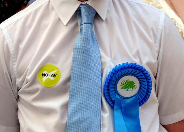 Conservative Party supporter wearing a Party badge and 'NO to AV' sticker during the referendum campaign.