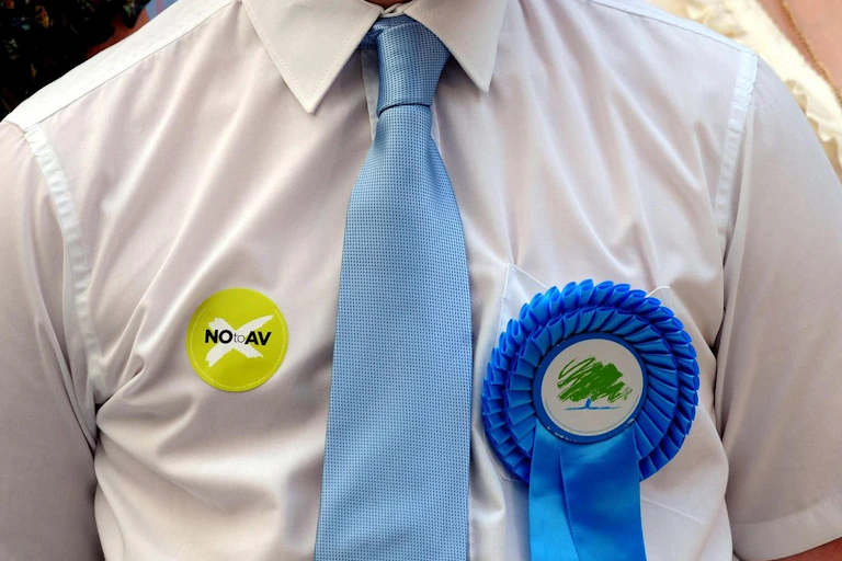 Conservative Party supporter wearing a Party badge and 'NO to AV' sticker during the referendum campaign.
